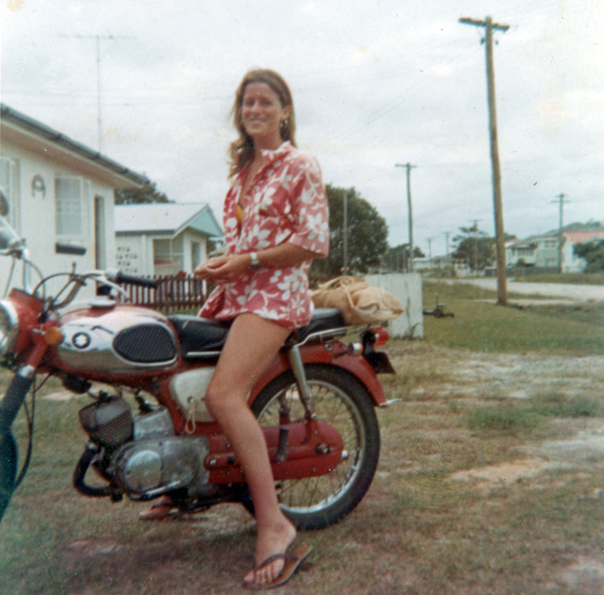 Woman seated on red motorcycle