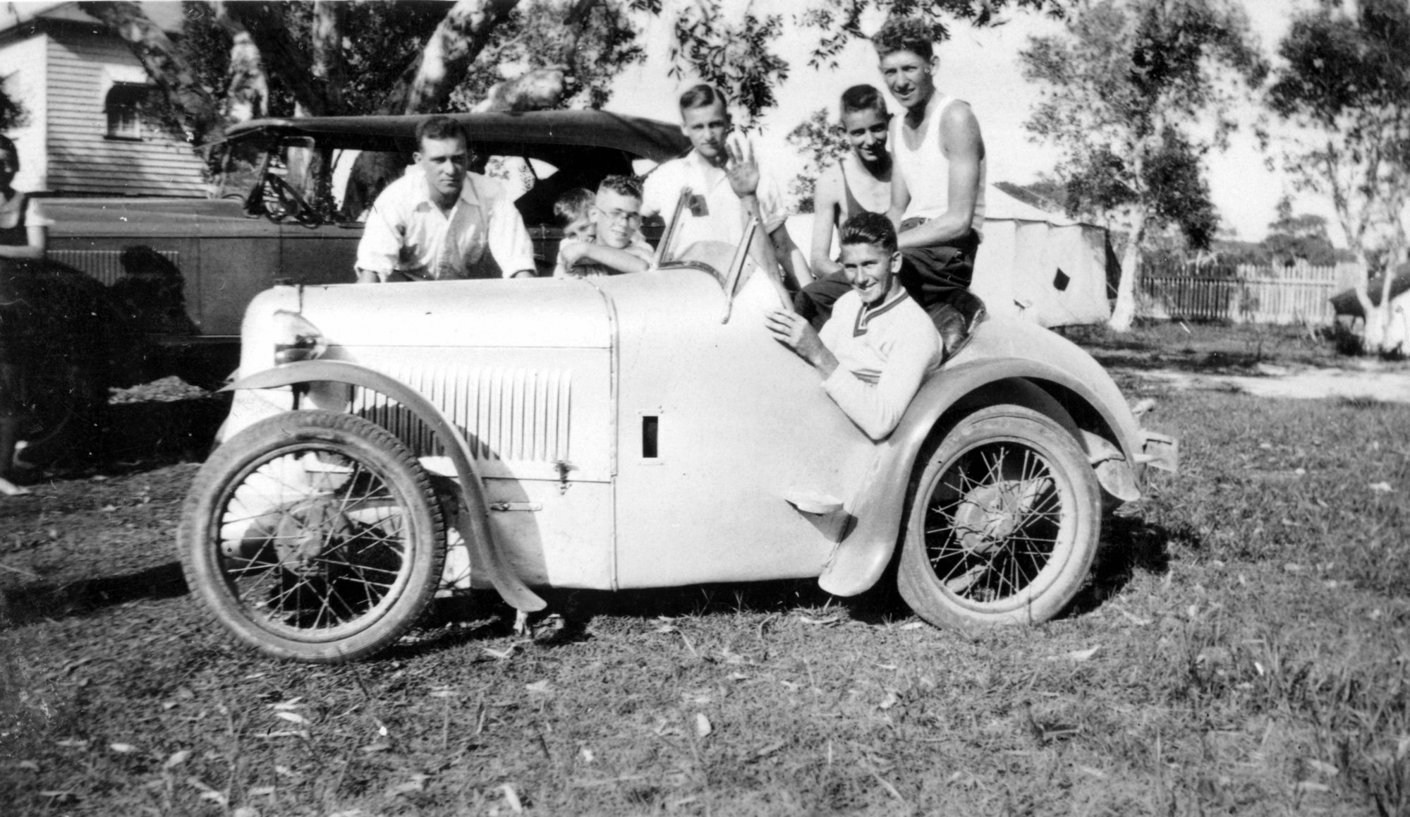 Youths gathered by their friends motorcar