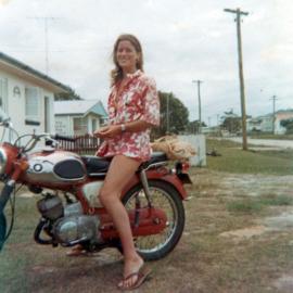 Woman seated on red motorcycle